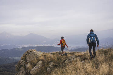 Älterer Mann und Frau mit Rucksack beim Wandern auf einem Berg - UUF28252