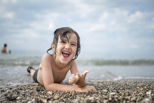 Unbekümmerter Junge genießt den Urlaub am Strand - ANAF00989