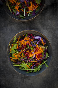 Studioaufnahme von zwei Tellern mit verzehrfertigem veganem Salat vor schwarzem Hintergrund - LVF09275