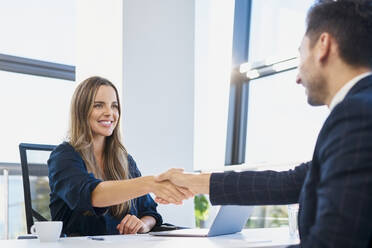 Happy recruiter doing handshake with candidate after job interview at office - BSZF02136