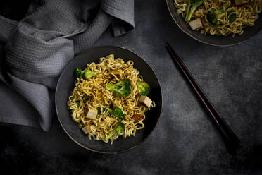 Studio shot of plate of ready-to-eat vegan noodles with broccoli, tofu and soy sauce - LVF09280