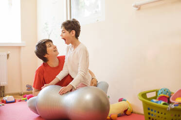 Caretaker and girl with disability playing in rehabilitation centre - OSF01385