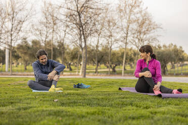 Glückliches reifes Paar übt Yoga im Park - JCCMF09352