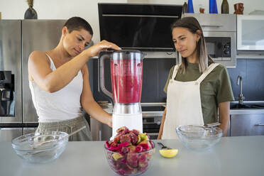 Freunde pürieren Kaktusfeigen für die Herstellung von Saft in der Küche zu Hause - FBAF02059