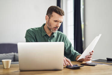 Worried man doing paperwork calculating finaces - BSZF02203