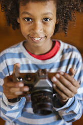 Smiling boy holding antique camera - LJF02485