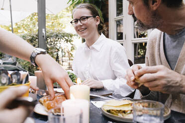 Glückliche Frau genießt Essen mit Familie im Restaurant - MASF34711