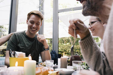 Lächelnder Mann beim Essen mit Familie im Restaurant - MASF34712