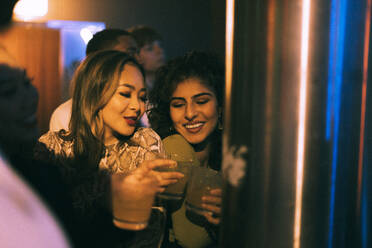 Cheerful young friends with drinks enjoying in club on weekend - MASF34779