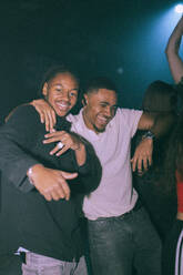 Portrait of cheerful young man dancing with male friend at nightclub - MASF34794