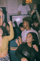 Fröhliche junge multirassische Männer und Frauen tanzen in einem Nachtclub - MASF34795