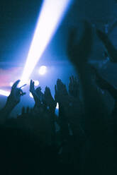 Silhouette erhobener Hände von Frauen und Männern, die in einem Nachtclub tanzen - MASF34808