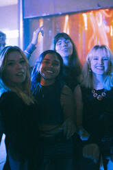 Porträt von glücklichen jungen gemischtrassigen Frauen, die sich gemeinsam in einem Nachtclub vergnügen - MASF34810