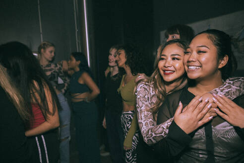 Glückliche junge Frau, die ihren Freund umarmt und in einem Nachtclub genießt - MASF34837