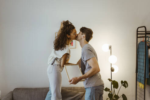 Seitenansicht eines sich küssenden Paares an der Wand zu Hause - MASF34966