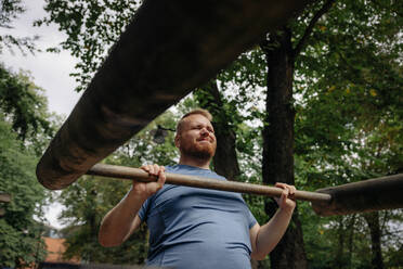 Entschlossener fettleibiger Mann beim Sport im Park - MASF35064