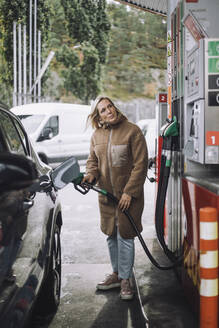 Reife Frau tankt Auto an einer Tankstelle - MASF35153