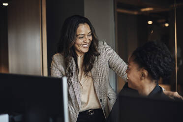 Happy female business colleagues communicating with each other - MASF35213