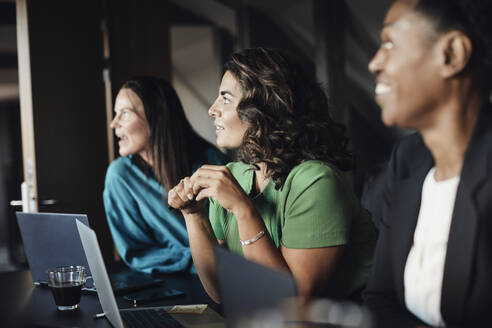 Geschäftsfrauen schauen während einer Besprechung im Büro weg - MASF35255