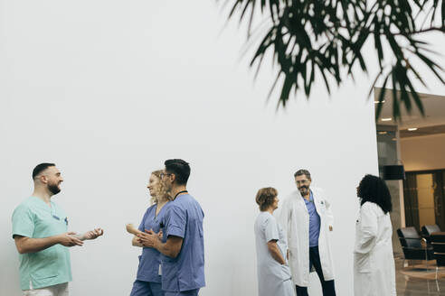Ein Team aus männlichen und weiblichen Mitarbeitern des Gesundheitswesens bespricht sich im Krankenhaus - MASF35283