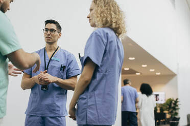 Männliches und weibliches Gesundheitspersonal im Gespräch mit einem Kollegen im Krankenhaus - MASF35285