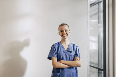 Young Female Nurse With Folded Arms Standing In Hospital Stock