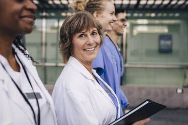 Porträt einer Ärztin mit einer Akte in der Hand von Krankenhauskollegen - MASF35381