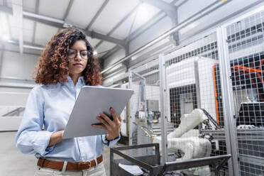 Junger Ingenieur mit Tablet-PC in der Fabrik - AAZF00037