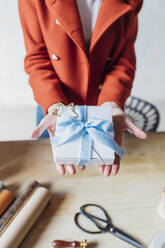 Hands of woman holding gift box - MEUF08852