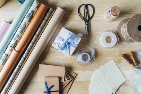Wrapping paper with gifting material on desk - MEUF08854