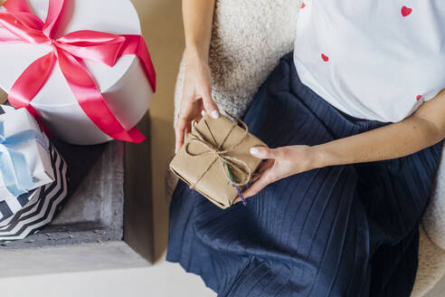 Frau mit Geschenkboxen auf einem Stuhl sitzend - MEUF08898