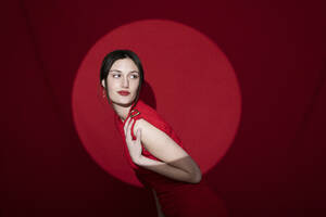 Schöne junge Frau posiert über roten Hintergrund - LMCF00057