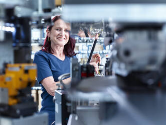 Glücklicher reifer Ingenieur bei der Arbeit in einer Fabrik - CVF02301