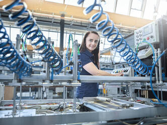 Smiling engineer operating machines at factory - CVF02306