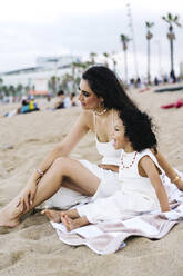 Nachdenkliche Mutter und Sohn sitzen im Sand am Strand - JJF00072