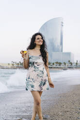 Happy woman holding wine glass at beach - JJF00081