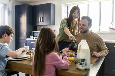 Glücklicher Mann und Frau beim Frühstück mit Kindern zu Hause - WPEF07203