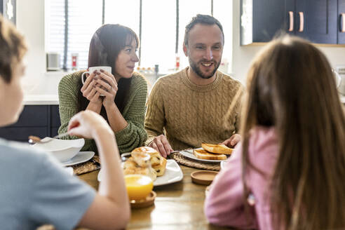 Glücklicher Mann und Frau beim Frühstück mit Kindern zu Hause - WPEF07204
