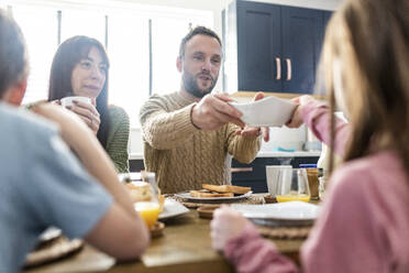 Glückliche Familie beim gemeinsamen Frühstück zu Hause - WPEF07206