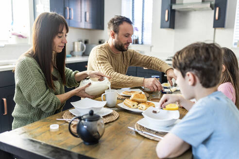 Familie beim gemeinsamen Frühstück in der Küche - WPEF07209