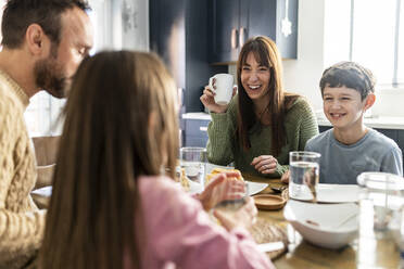 Glückliche Familie beim Frühstück am Tisch - WPEF07228