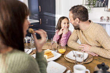 Glückliches Mädchen mit Vater beim Frühstück am Esstisch - WPEF07233