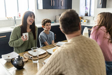 Glückliche Mutter und Vater beim gemeinsamen Frühstück mit den Kindern zu Hause - WPEF07241