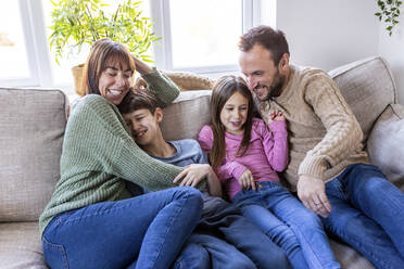 Happy man and woman spending time with children at home - WPEF07268