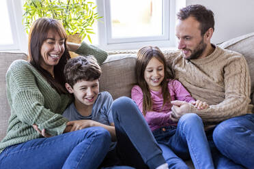 Happy family enjoying together in living room at home - WPEF07269