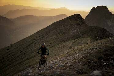 Mountainbiker fahren Fahrrad bei Sonnenuntergang - MALF00423