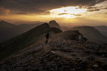 Man doing mountain biking at sunset - MALF00427