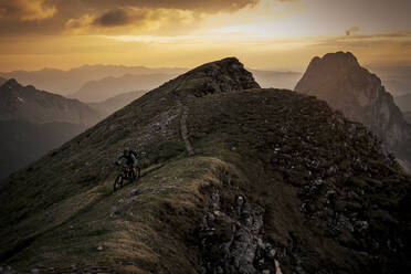 Man riding mountain bike on summit - MALF00430