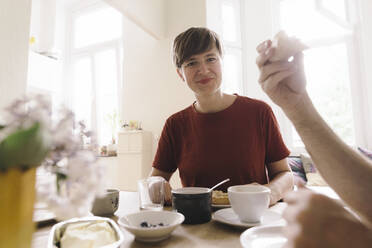 Lächelnde Frau mit Frühstück auf dem Tisch zu Hause - JOSEF16980