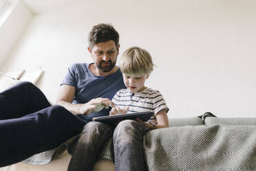 Vater und Sohn benutzen einen Tablet-PC zu Hause - JOSEF16986
